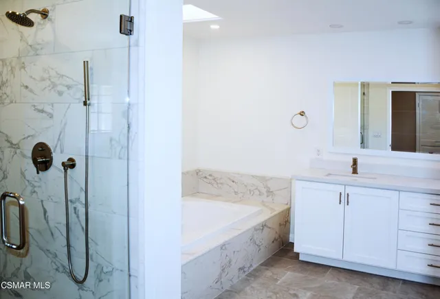 a bathroom with a tub sink and mirror