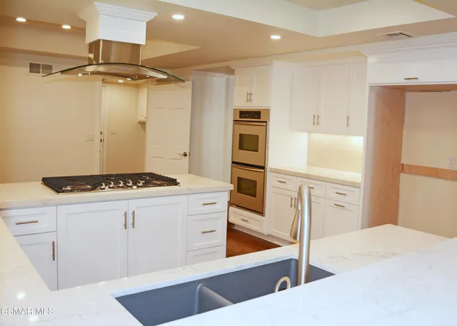 a kitchen with a stove a refrigerator and a sink