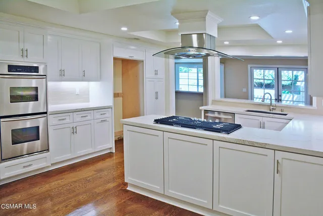 a kitchen with stainless steel appliances white cabinets and a sink