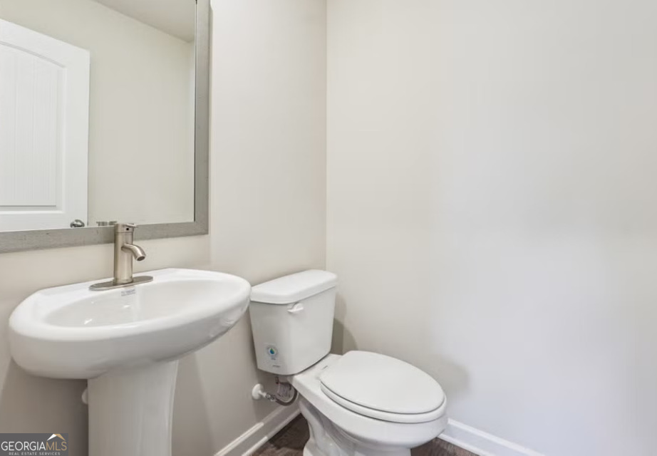107 Garden Walk West Point, GA 31833 - Photo 5 of 9 a white toilet sitting next to a bathroom sink
