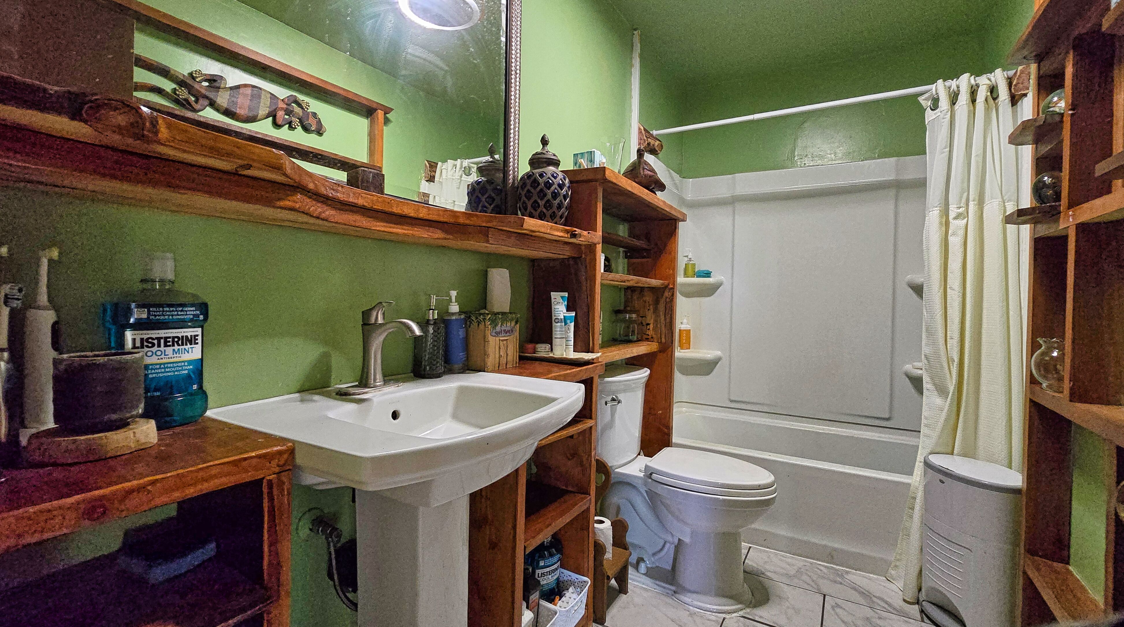 94-6491 Kamaoa Road Naalehu, HI 96772 - Photo 13 of 30 a bathroom with a sink a toilet and a mirror