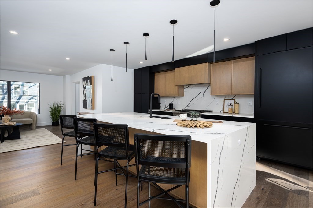 14 Edith Street, Unit 14 Arlington, MA 02474 - Photo 19 of 42 a kitchen with a table chairs stove and wooden floor