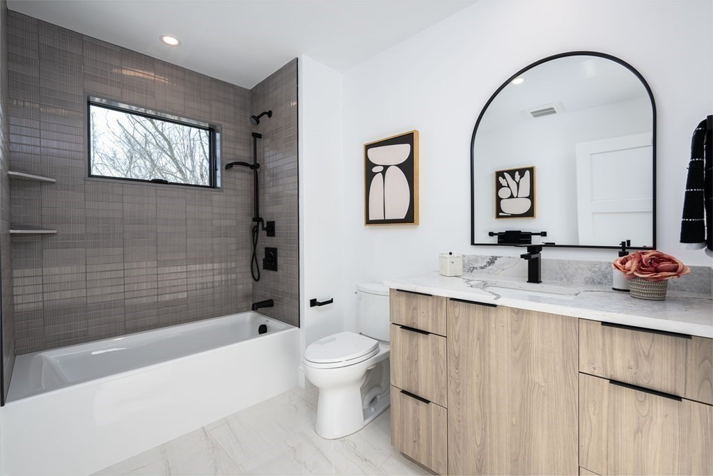 14 Edith Street, Unit 14 Arlington, MA 02474 - Photo 25 of 42 a bathroom with a toilet sink and mirror