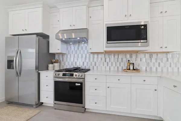 a kitchen with white cabinets and stainless steel appliances