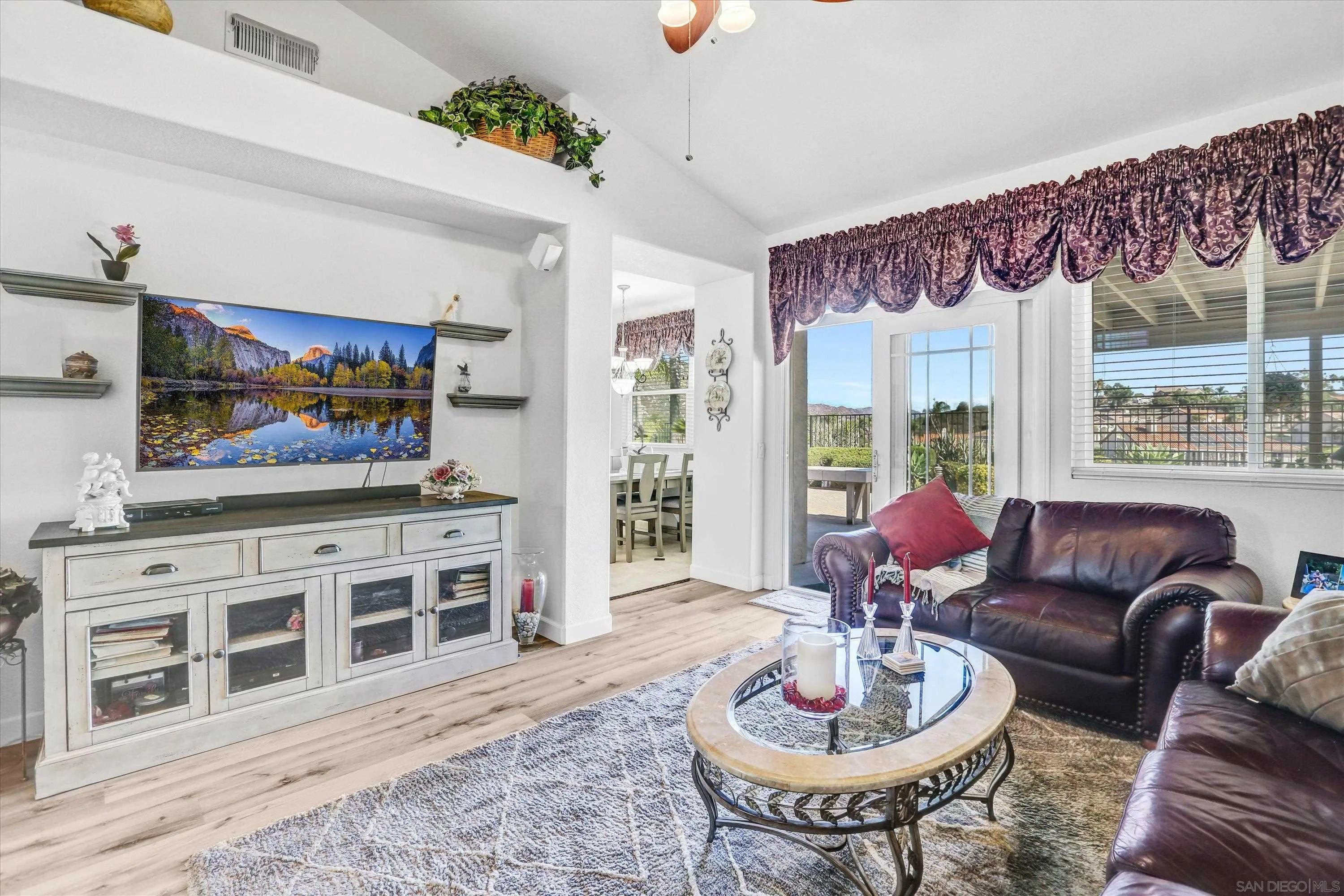 8983 Chestnut Roan Way Alpine, CA 91901 - Photo 16 of 33 a living room with furniture a flat screen tv and a floor to ceiling window