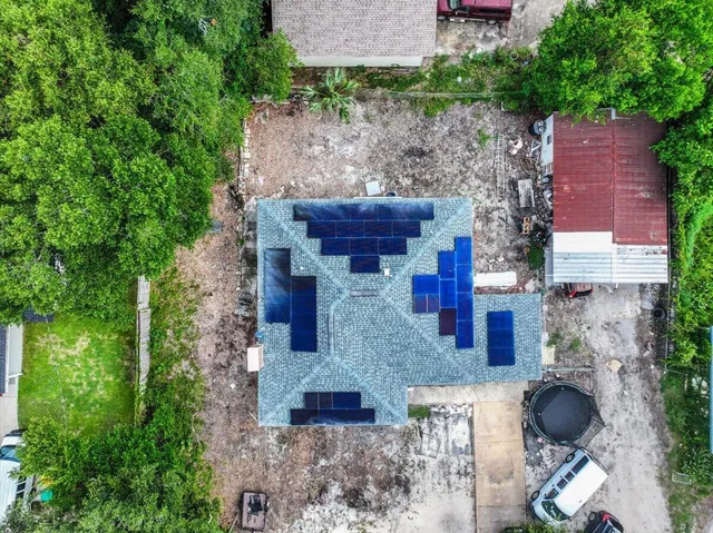 a aerial view of a house with plants and statue