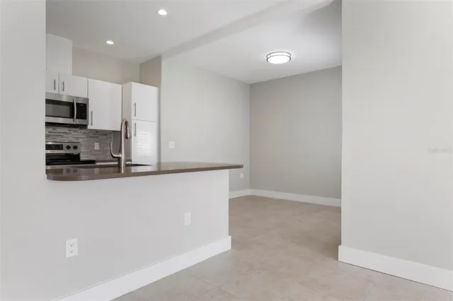 a kitchen with kitchen island a counter top space cabinets and stainless steel appliances