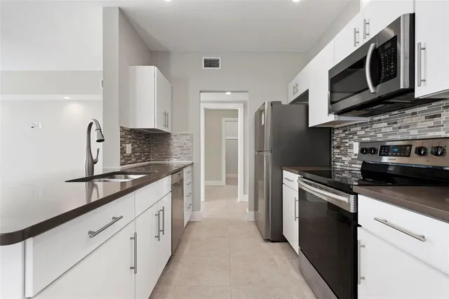 a kitchen with stainless steel appliances granite countertop a sink and a stove