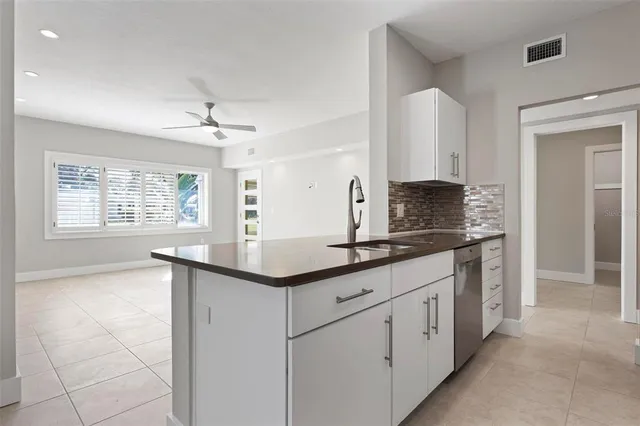 a kitchen with stainless steel appliances granite countertop a sink and a stove top oven with wooden floor