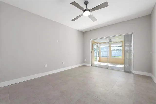 an empty room with a ceiling fan and a window