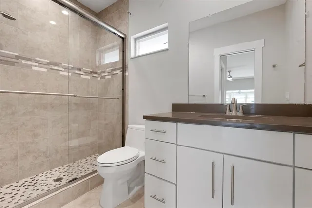 a bathroom with a sink toilet a mirror and shower