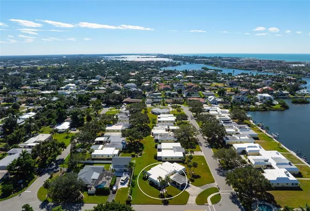 an aerial view of a city with lots of residential buildings ocean and mountain view in back