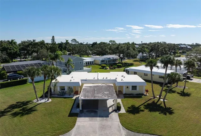 a living room with stainless steel appliances furniture a rug and a large window