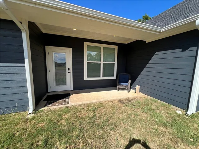 a view of house with backyard porch and wooden bench