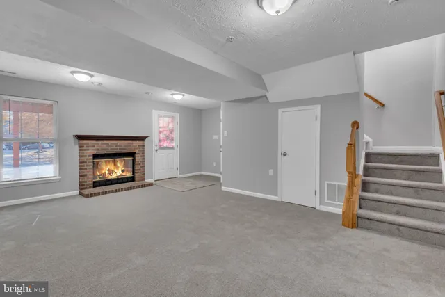 a view of an empty room with a fireplace and a window