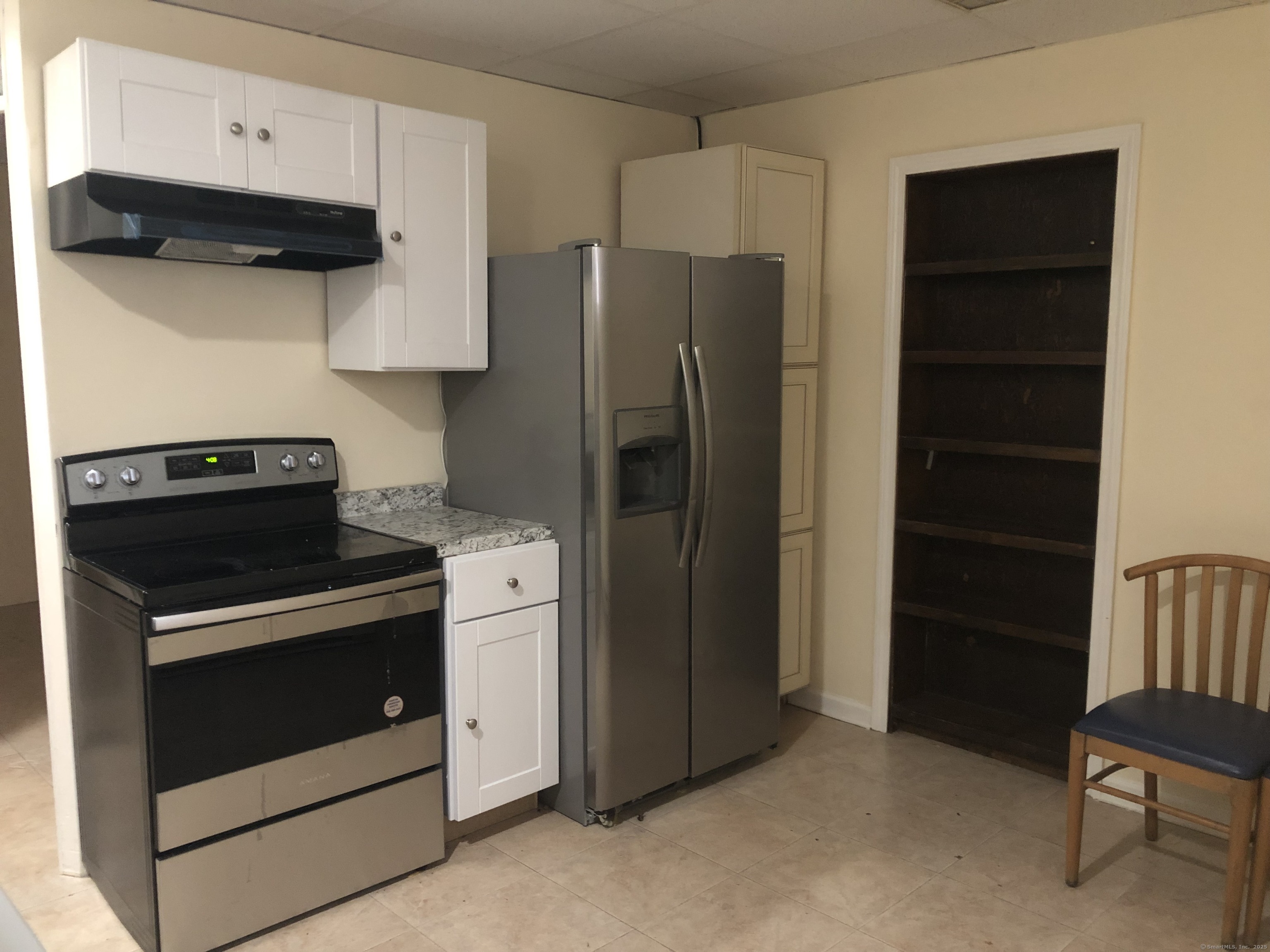 a kitchen with stainless steel appliances white cabinets and a refrigerator