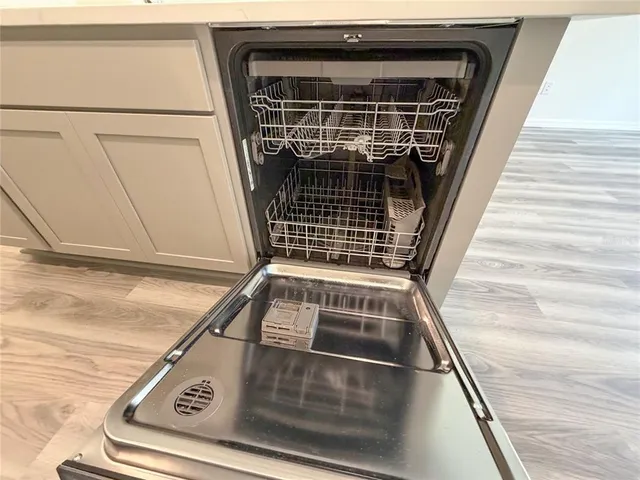 a large kitchen with stainless steel appliances a large counter top a stove and a refrigerator