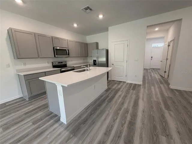 a kitchen with a sink and white cabinets