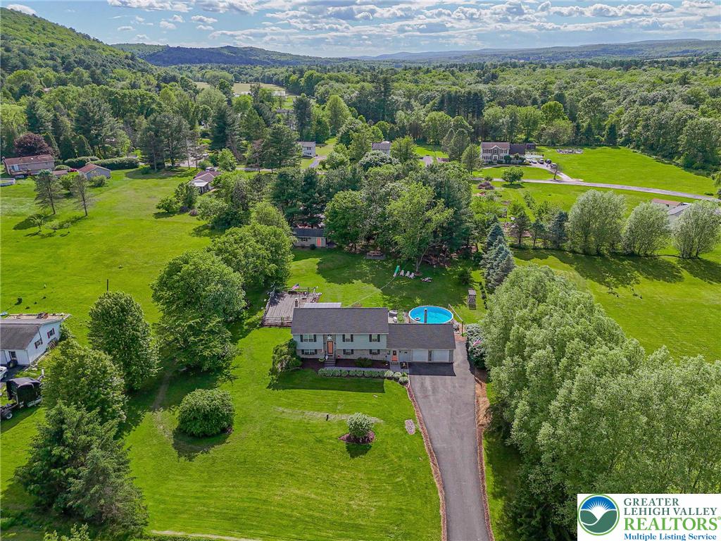 341 Lower Greenhill Road Kunkletown, PA 18058 - Photo 2 of 69 An aerial perspective reveals a serene countryside estate featuring a private pool and winding driveway amidst abundant greenery.