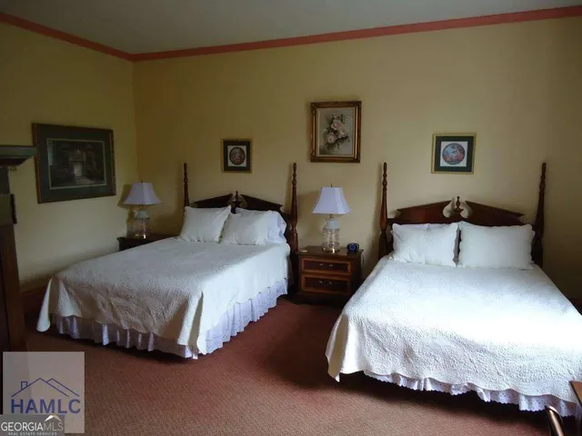 a bedroom with two beds and painting on the wall