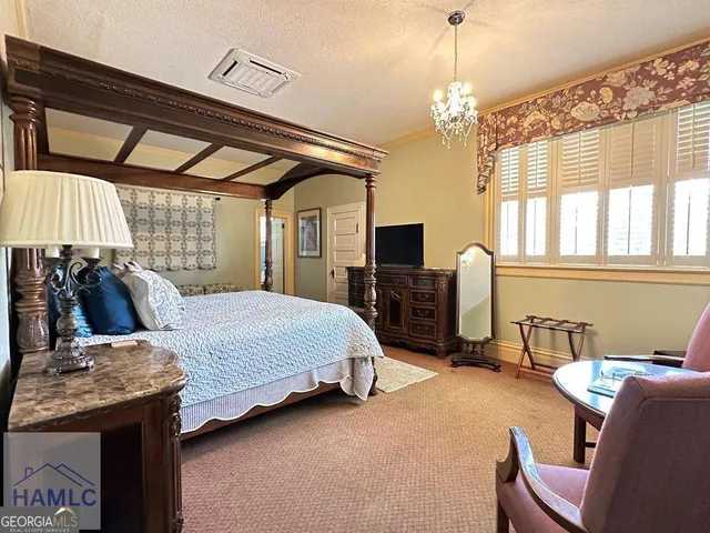 a bedroom with a bed and a chandelier