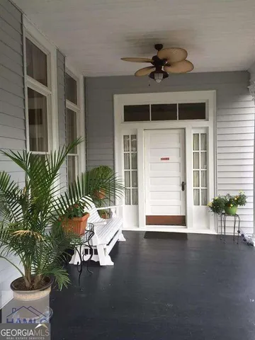 a view of a room with wooden floor and a potted plant