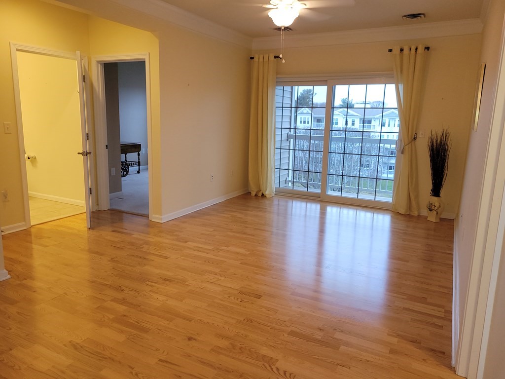 9 Abigail Way, Unit 4010 Reading, MA 01867 - Photo 11 of 37 a view of an empty room with wooden floor and a window
