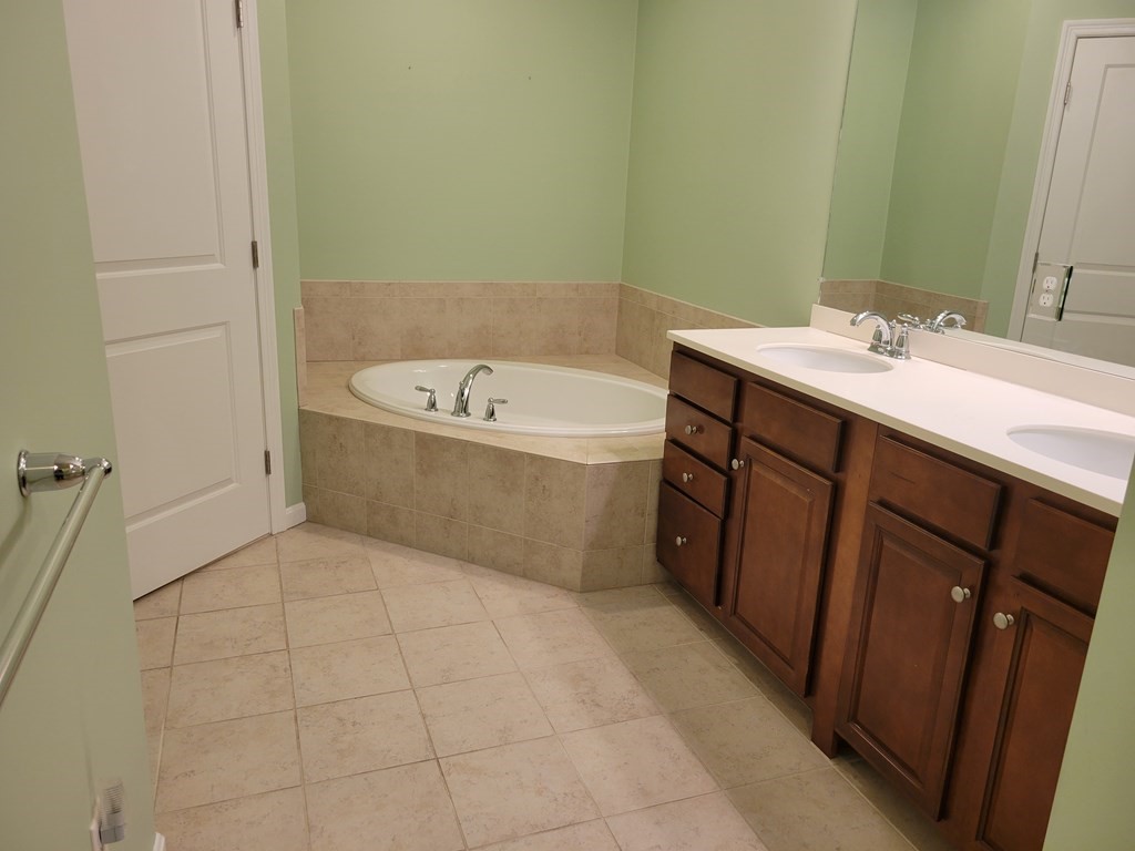 9 Abigail Way, Unit 4010 Reading, MA 01867 - Photo 18 of 37 a spacious bathroom with a bathtub sink and mirror