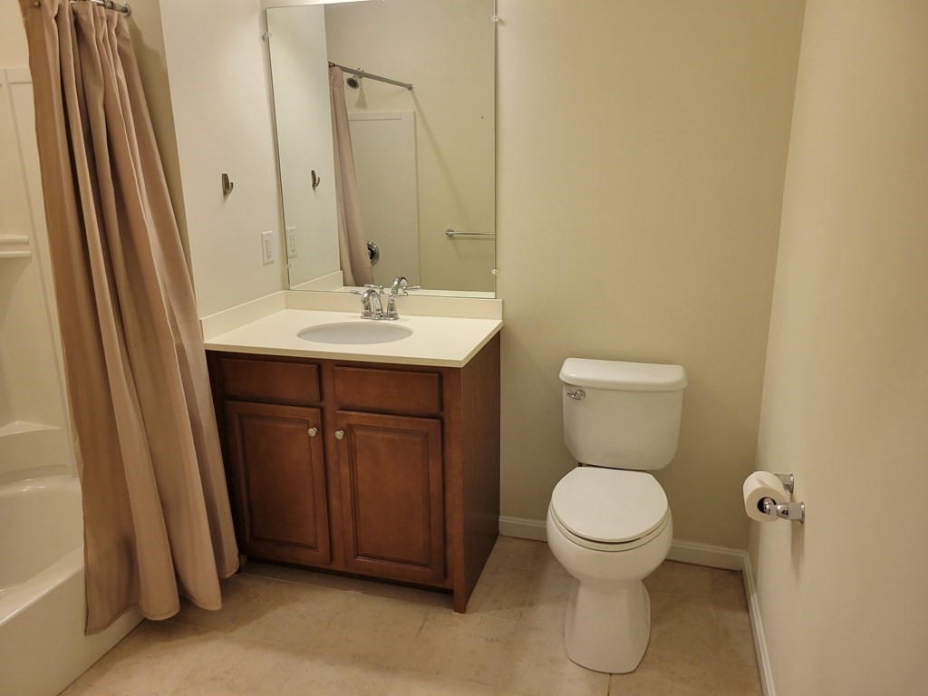 9 Abigail Way, Unit 4010 Reading, MA 01867 - Photo 24 of 37 a bathroom with a toilet a sink and mirror