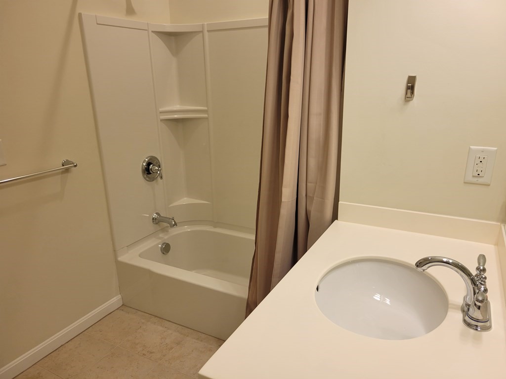 9 Abigail Way, Unit 4010 Reading, MA 01867 - Photo 25 of 37 a bathroom with a sink a mirror and a bathtub