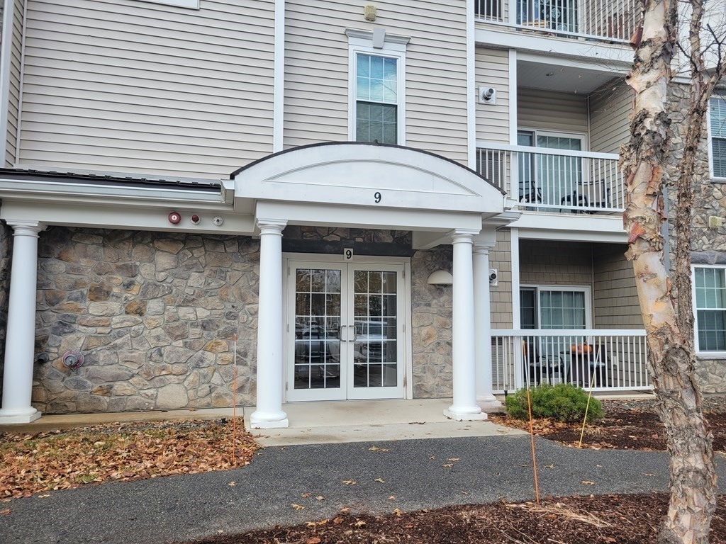 9 Abigail Way, Unit 4010 Reading, MA 01867 - Photo 3 of 37 a front view of a house with a yard and garage