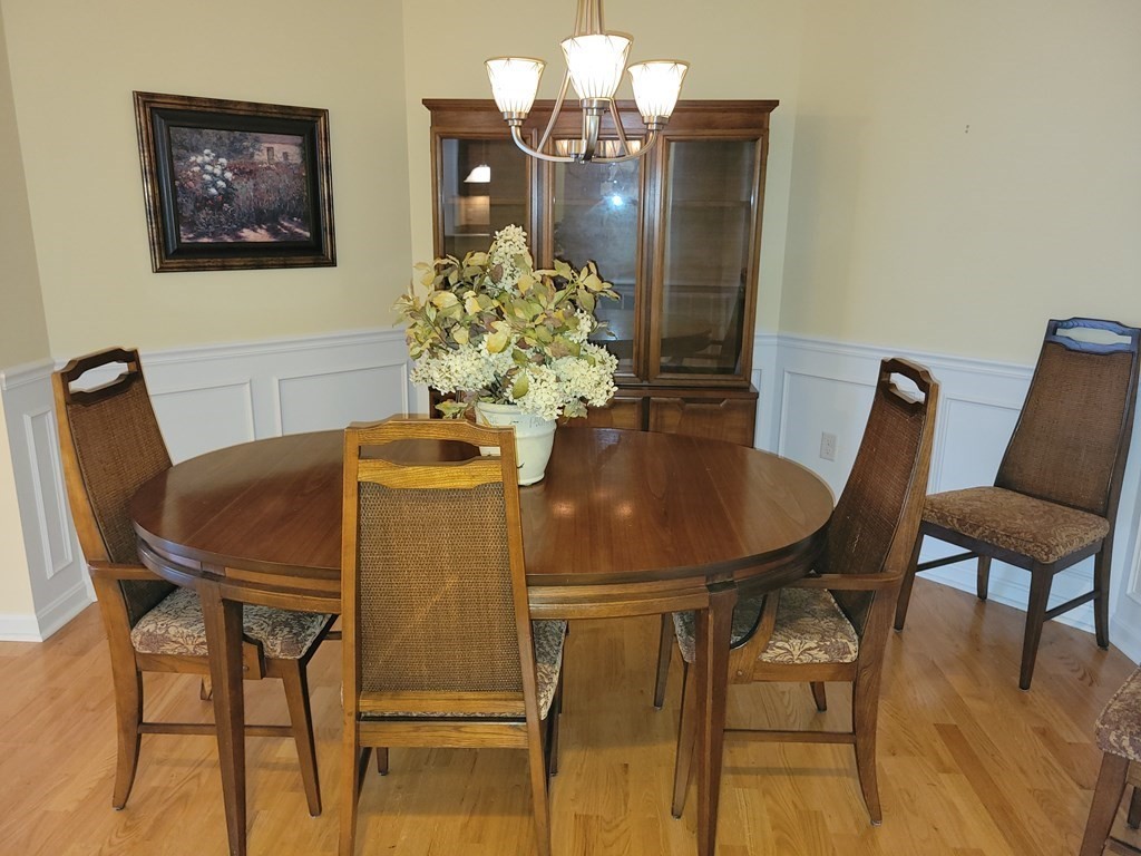 9 Abigail Way, Unit 4010 Reading, MA 01867 - Photo 8 of 37 a dining room with furniture and wooden floor