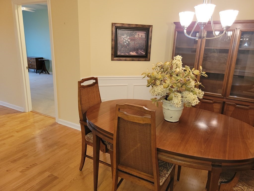 9 Abigail Way, Unit 4010 Reading, MA 01867 - Photo 9 of 37 a dining room with furniture and wooden floor