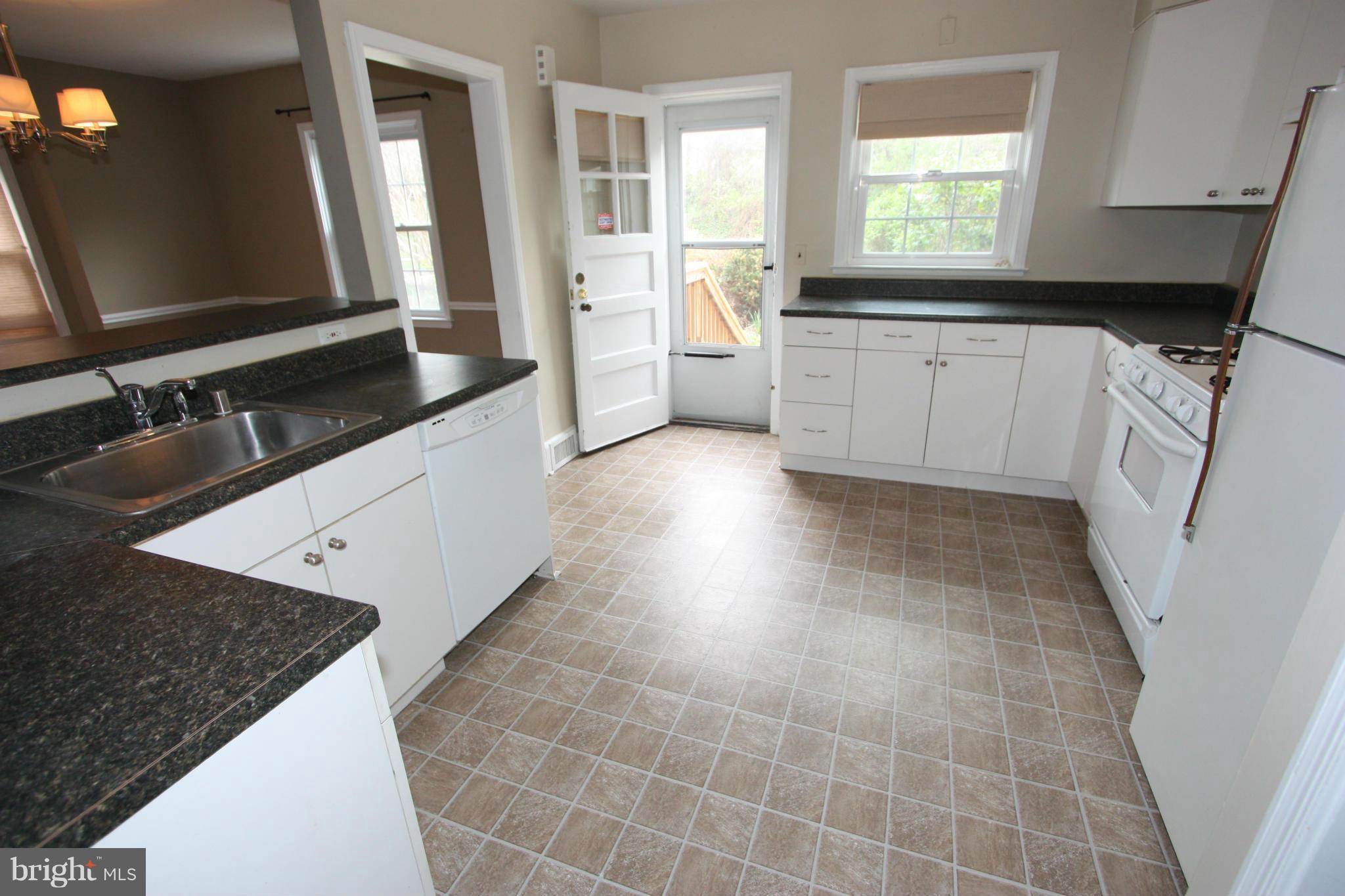 1932 Edgewood Road Parkville, MD 21286 - Photo 3 of 30 a kitchen with granite countertop a sink stove and cabinets