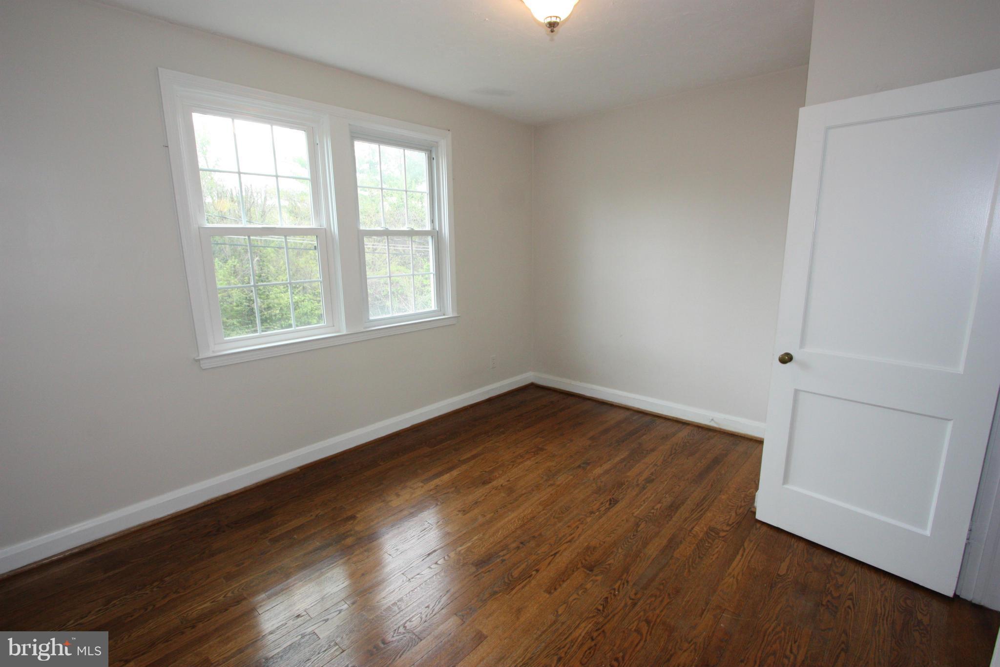 1932 Edgewood Road Parkville, MD 21286 - Photo 21 of 30 an empty room with wooden floor and windows