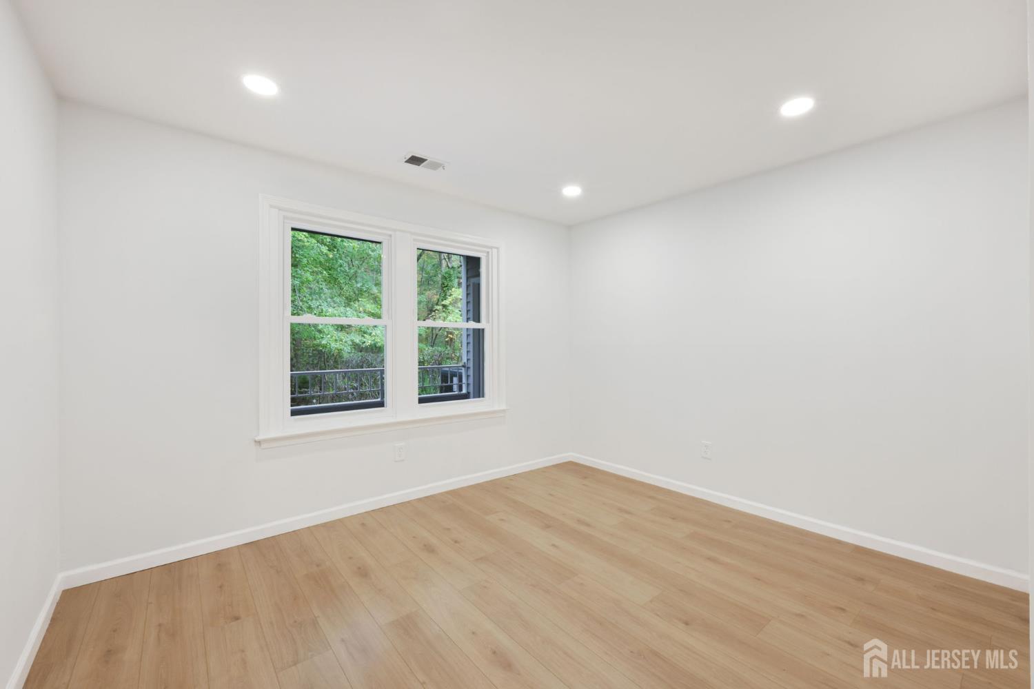 102 Raintree Court Helmetta, NJ 08828 - Photo 16 of 21 an empty room with wooden floor and windows