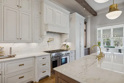a kitchen with granite countertop white cabinets and white appliances