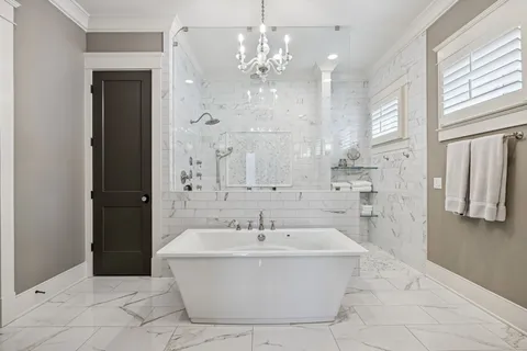 a white bath tub sitting in a bathroom and shower