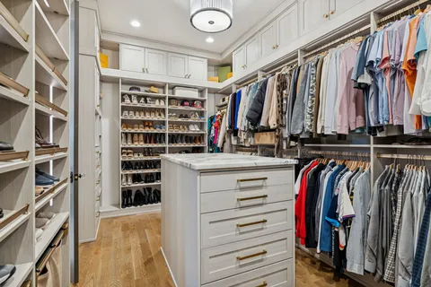 a view of walk in closet with clothes and shoes