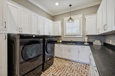 a kitchen with granite countertop a sink a stove and cabinets