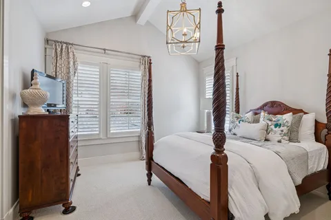 a bedroom with a bed and a chandelier