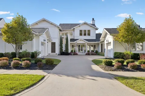 a front view of a house with a yard and outdoor seating