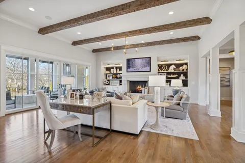 a living room with furniture a large window and a fireplace