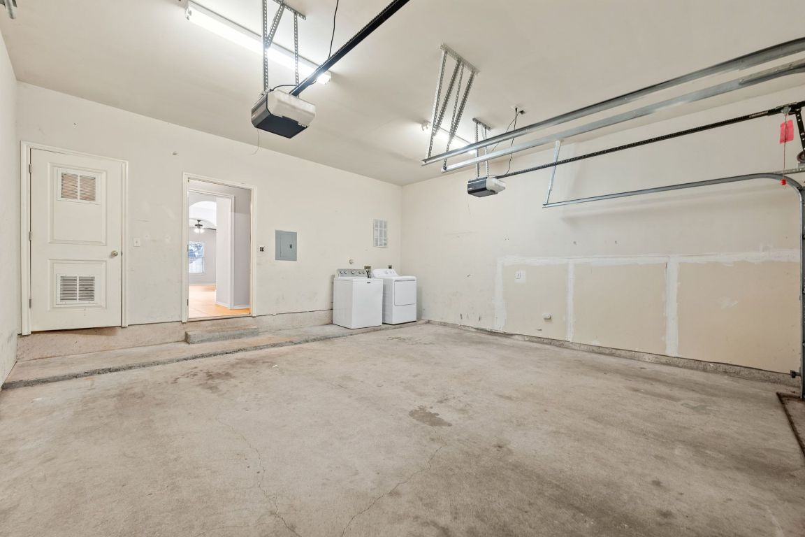 2906 Pearl Street, Unit B Austin, TX 78705 - Photo 26 of 30 Garage featuring washing machine and dryer, a garage door opener, and electric panel