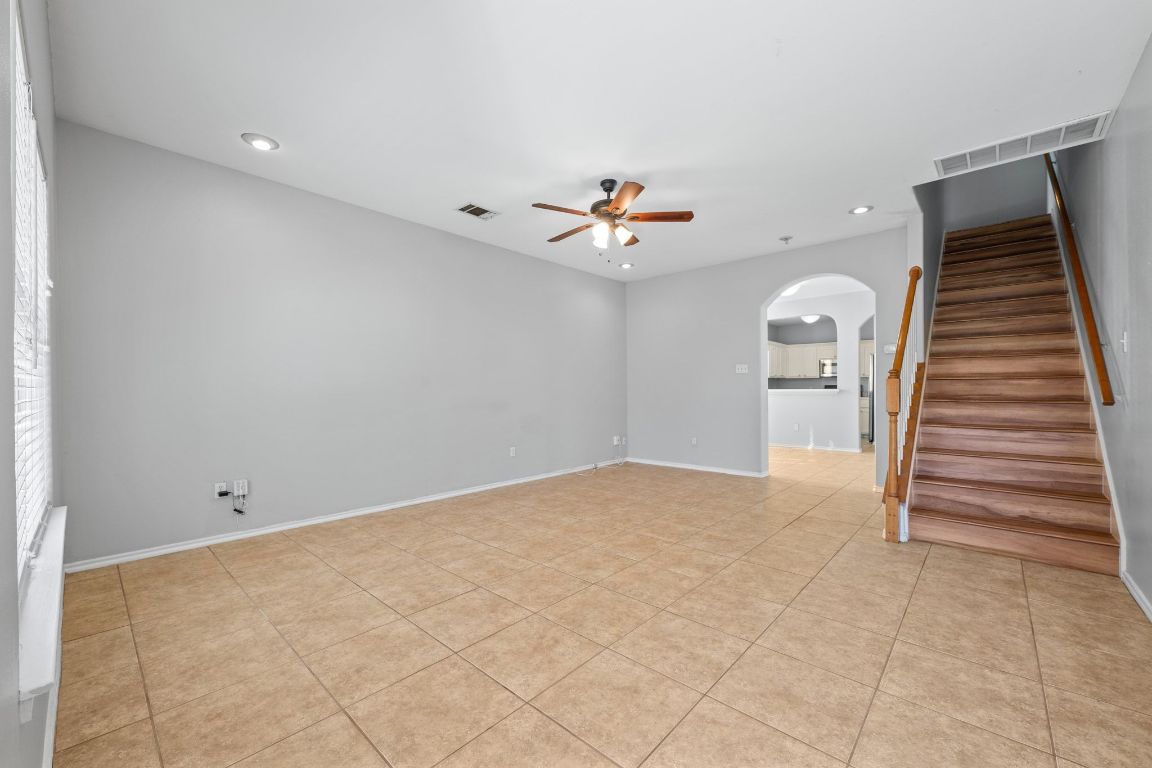 2906 Pearl Street, Unit B Austin, TX 78705 - Photo 4 of 30 Unfurnished room with arched walkways, recessed lighting, stairs, a ceiling fan, and light tile patterned flooring