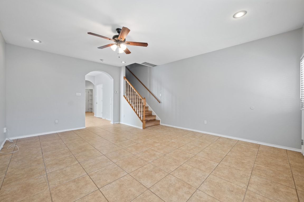 2906 Pearl Street, Unit B Austin, TX 78705 - Photo 6 of 30 Unfurnished room featuring arched walkways, a ceiling fan, recessed lighting, stairway, and light tile patterned flooring