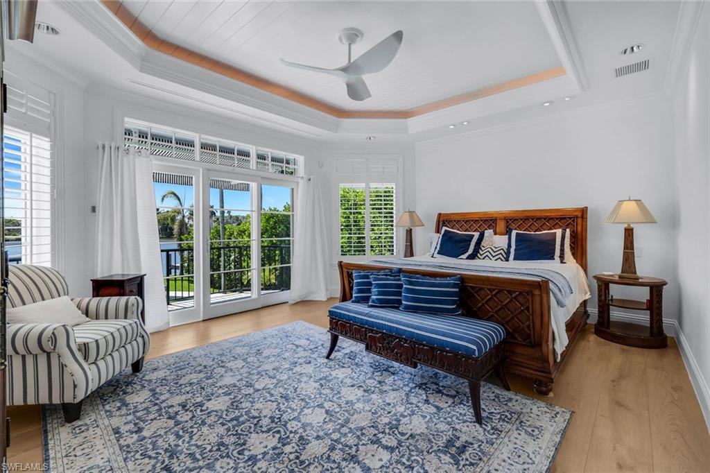 400 Springline Drive Naples, FL 34102 - Photo 24 of 37 Bedroom featuring light wood-style flooring, access to outside, a tray ceiling, crown molding, and a ceiling fan