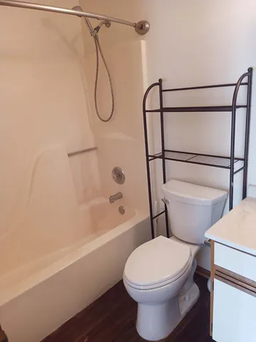 a white toilet sitting next to a bath tub and shower