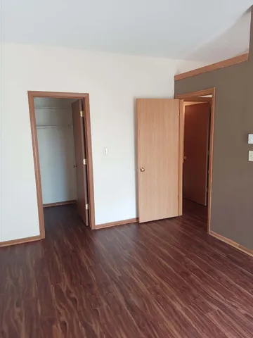 a view of an empty room with wooden floor and closet