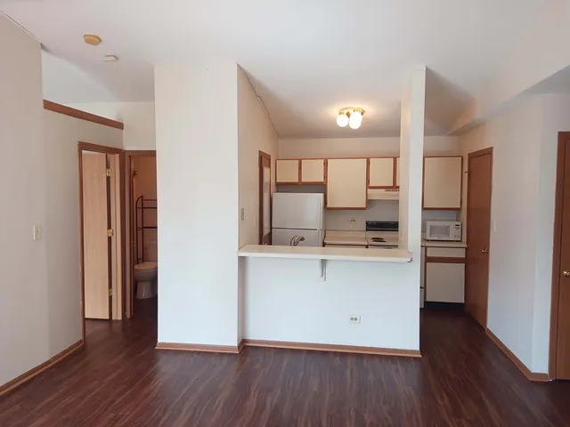 a kitchen with stainless steel appliances a refrigerator and wooden floor